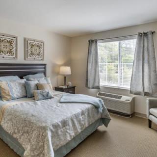 A cozy bedroom with a neatly made bed, soft lighting, and elegant decor.