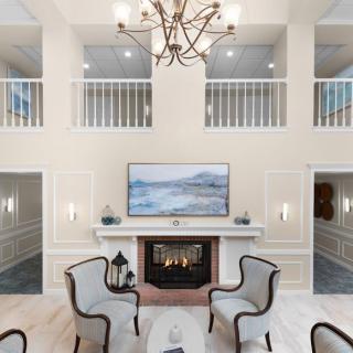 Luxurious and modern living room featuring a grand chandelier, elegant fireplace, and comfortable seating.