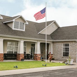 A residential house with an American flag in the front yard.