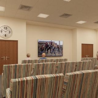 A waiting room with striped chairs, a wall-mounted television, and a clock.