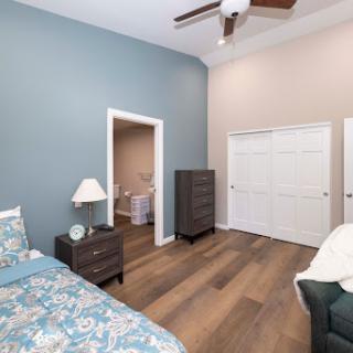 A cozy and modern bedroom featuring a calming blue accent wall and stylish furniture.