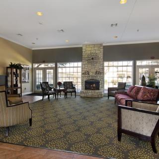 A spacious living room with a fireplace, ample seating, and large windows providing natural light.