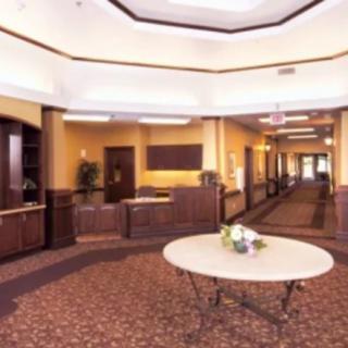 Spacious lobby with a reception desk and decorative table.