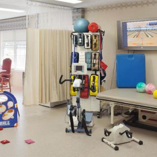 A well-equipped physical therapy room with various exercise equipment and rehabilitation tools.