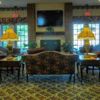 A cozy living room with a sofa, lamps, and a fireplace, featuring elegant interior design.