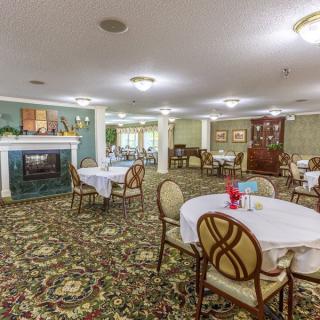Spacious dining area with round tables and a fireplace.