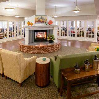 A cozy living room with a central fireplace surrounded by comfortable seating.