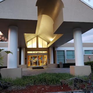 The modern entrance of a building, beautifully lit during the evening.