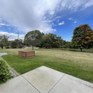 A scenic park view with trees and a partly cloudy sky.