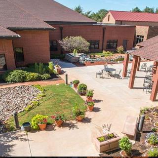 A landscaped courtyard with flower pots and greenery surrounded by buildings.