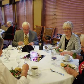 A group of seniors enjoying a meal together at a restaurant.