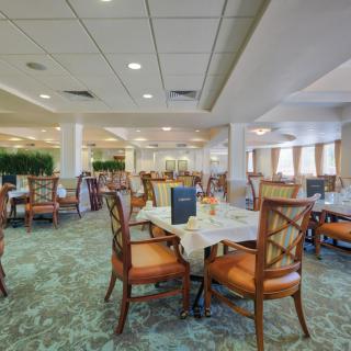An empty restaurant dining area with neatly arranged tables and chairs.