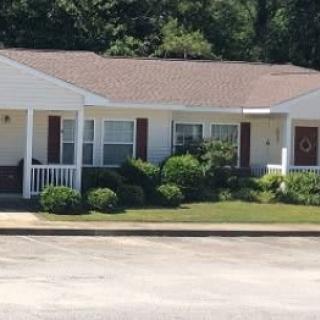 A suburban house with a porch and manicured front yard.