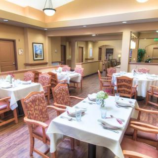 A spacious dining area with neatly arranged tables and chairs set for a meal.