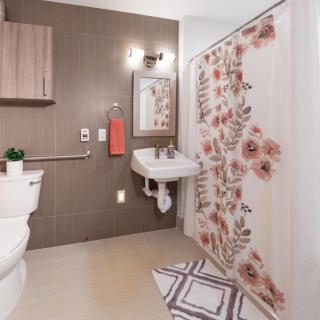 A modern bathroom with a floral-patterned shower curtain and stylish decor.