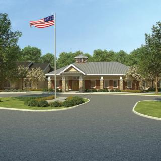 A building with a driveway and an American flag in front.