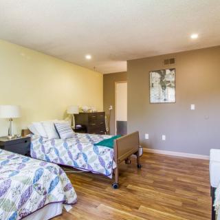 A cozy bedroom with twin beds, wood flooring, and soft lighting.