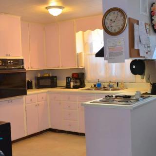 A cozy kitchen interior with white cabinets and modern appliances.