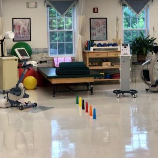 A physical therapy room equipped with exercise machines and rehabilitation tools.