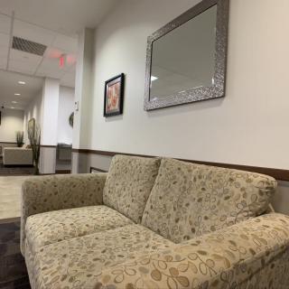 A cozy waiting room with a patterned sofa and decorative elements.