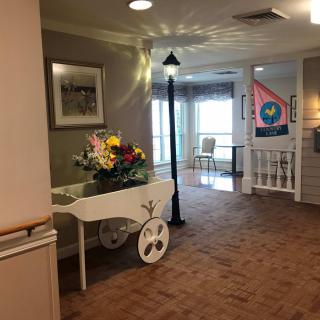 A decorated hallway with a flower cart and lamp post.