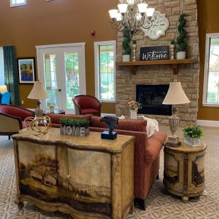 A cozy living room with elegant furnishings and a stone fireplace.