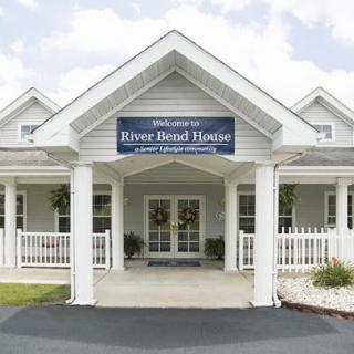 A welcoming front entrance of a house with a porch and sign.