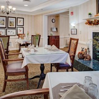 An elegant dining room with neatly arranged tables and chairs, adorned with tasteful decor and artwork on the walls.