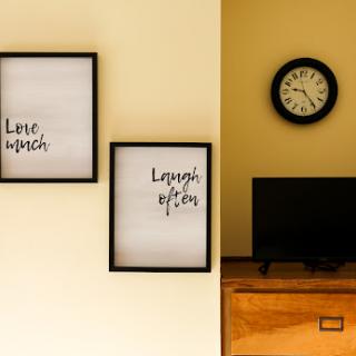 A cozy corner featuring inspirational wall art and a classic clock.
