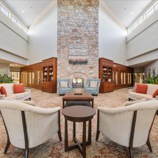 A spacious and elegantly designed lobby with comfortable seating and a central fireplace.