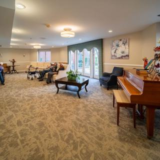 A spacious living room with multiple pianos and comfortable seating.