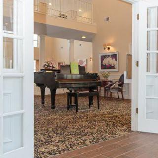 A spacious living room featuring a grand piano and elegant decor.