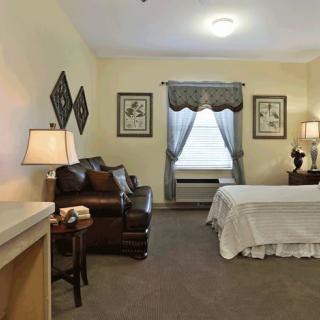 A cozy bedroom featuring a bed, sofa, and stylish decor.
