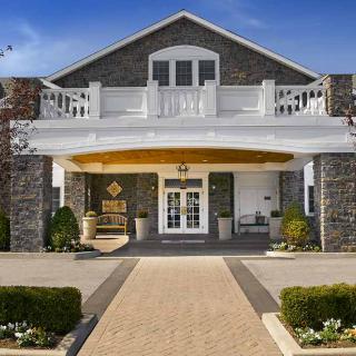 A beautiful stone facade house with a grand entrance and balcony.