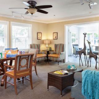 A cozy living room with ample natural light, featuring comfortable seating and elegant decor.