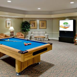A cozy game room featuring a pool table, comfortable seating, and a television.