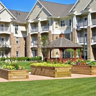 A residential apartment complex with a beautifully landscaped garden and gazebo.