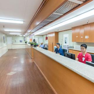 A view of the reception area in a hospital, featuring staff members attending to patients.