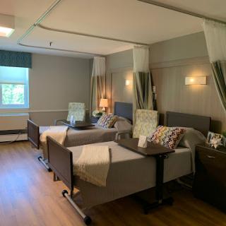 A well-designed hospital room with two patient beds, showcasing a comfortable and inviting atmosphere for recovery.