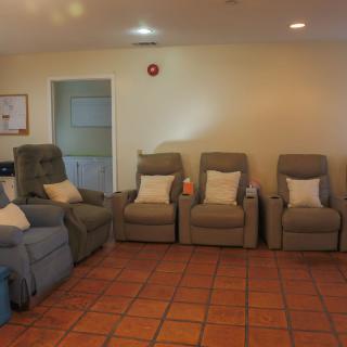 A cozy living room with multiple recliners arranged in a row.