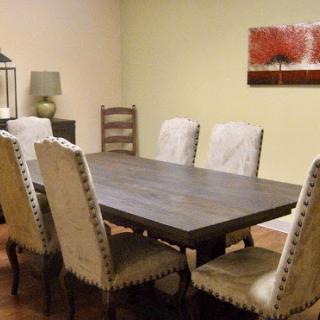 A cozy dining room featuring a wooden table surrounded by elegant chairs, complemented by tasteful artwork on the wall.
