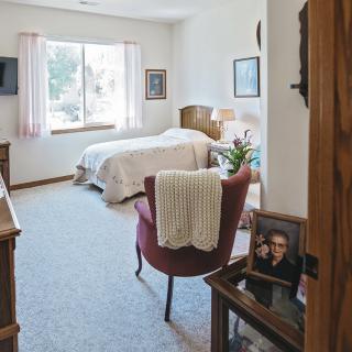 A cozy, well-decorated bedroom with a large window and comfortable furnishings.