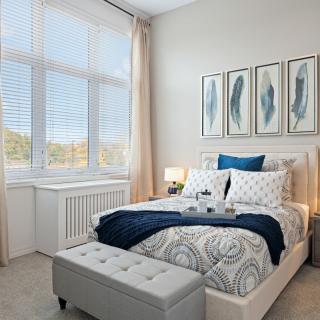 A cozy and elegantly decorated bedroom with large windows and stylish artwork.