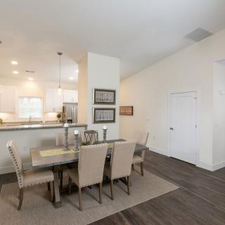 Modern dining area with an open concept kitchen and neutral decor.