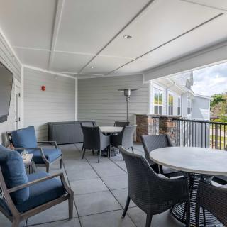 A modern covered patio with outdoor seating and tables.