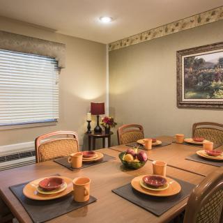 A well-decorated dining room with a neatly set table and warm lighting.