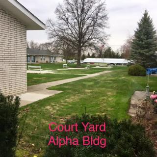 A serene courtyard with a green lawn and clear pathways.