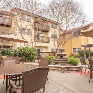 A cozy apartment courtyard featuring a fountain and patio seating.