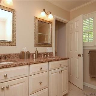 A modern bathroom with a double sink vanity and elegant lighting.
