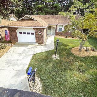 Aerial view of a suburban house with a garage and well-maintained lawn.